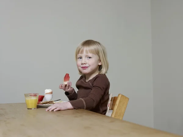 Girl sits eating melon for breakfast — Stock Photo, Image