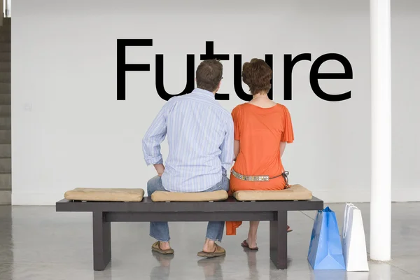 Couple on bench reading English text — Stock Photo, Image