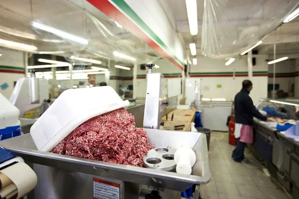 Minced meat in container with employee — Stock Photo, Image