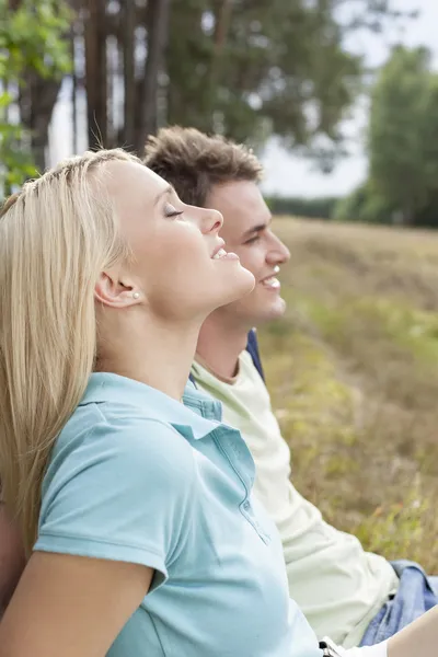 Woman  relaxing by man in forest — Stock Photo, Image