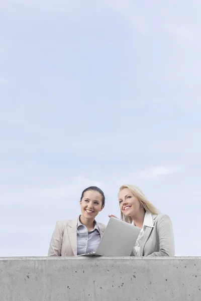 Geschäftsfrauen mit Laptop schauen weg — Stockfoto