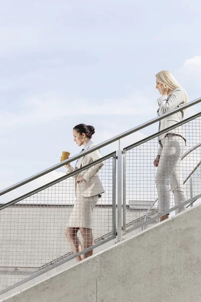 Businesswomen moving down stairs together — Stock Photo, Image