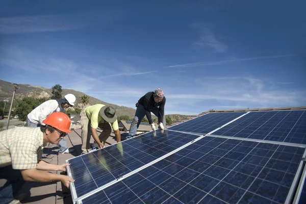 Homens que colocam grande painel solar — Fotografia de Stock