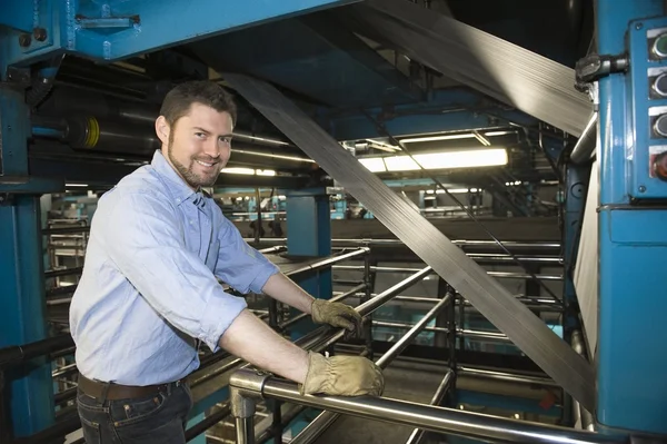 Man som arbetar i tidningen fabrik — Stockfoto