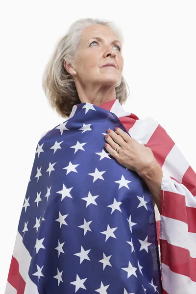Старшая женщина, завернутая в американский флаг — стоковое фото