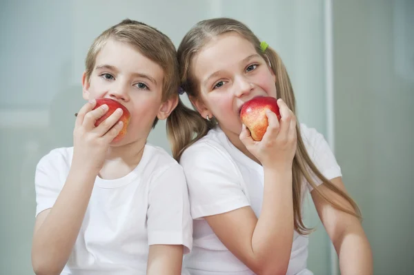 Мальчик и девочка едят яблоки — стоковое фото