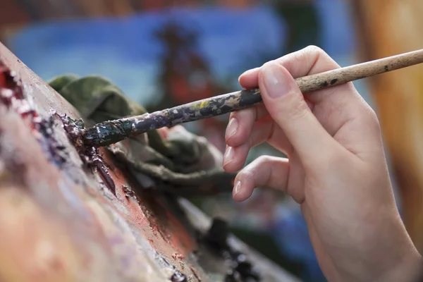 Woman holds paintbbrush — Stock Photo, Image