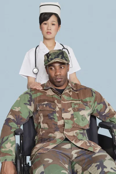 Nurse comforting disabled soldier in wheelchair — Stock Photo, Image