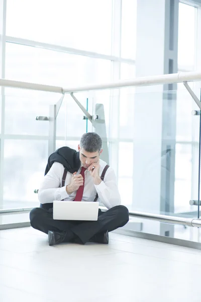 Zakenman op verdieping met behulp van laptop — Stockfoto