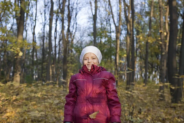 Дівчина стоїть під падаючим листям — стокове фото
