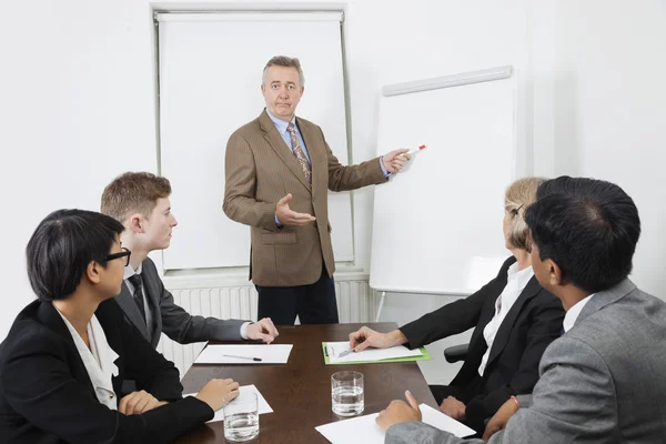 Homem usando quadro branco em reunião de negócios — Fotografia de Stock