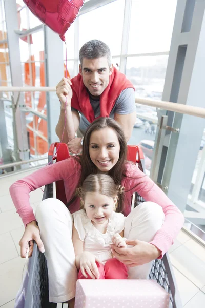 Mother and daughter in trolley with father — Stock Photo, Image