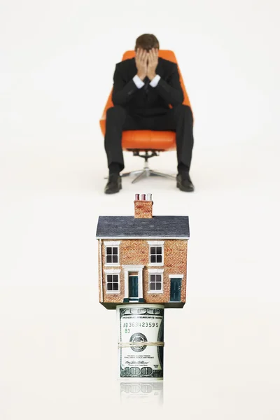 Casa en la parte superior de rollo de facturas con hombre de negocios preocupado —  Fotos de Stock