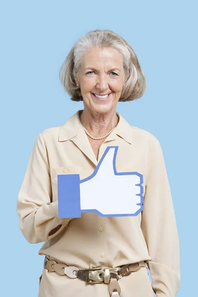 Senior woman holding fake like button — Stock Photo, Image