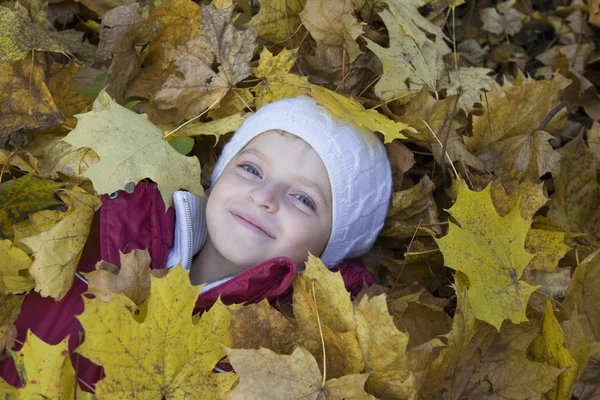 Meisje liggen in bladeren — Stockfoto
