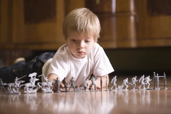 Niño jugando con soldados de juguete —  Fotos de Stock