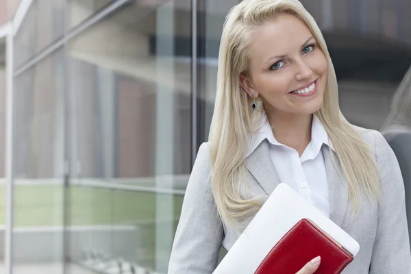 Zakenvrouw permanent door glazen wand — Stockfoto