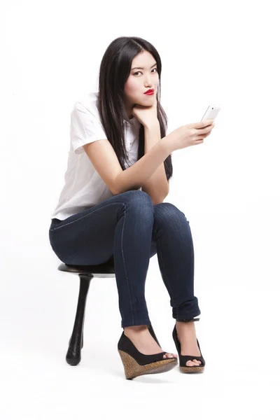 Woman on stool with mobile phone — Stock Photo, Image