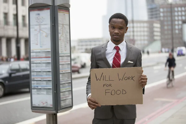 Empresario sosteniendo letrero trabajará para la comida — Foto de Stock