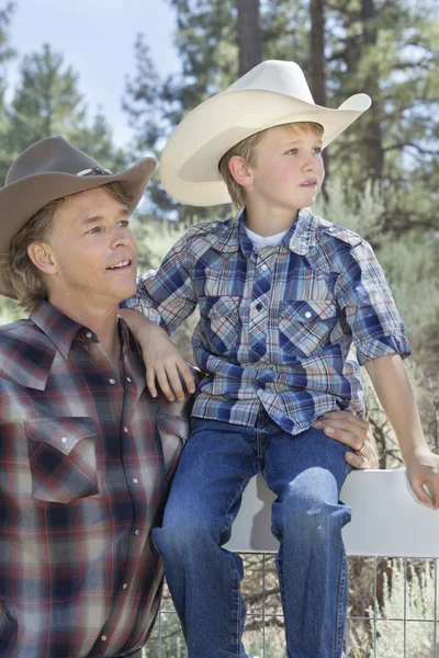 Far och son bär cowboy hattar — Stockfoto