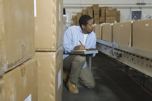 Hombre inspeccionando cajas —  Fotos de Stock