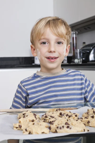 Boy in front of baking tray of cookies — Stock Photo, Image