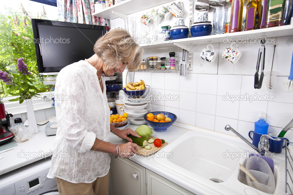Senior woman chopping fresh vegetables