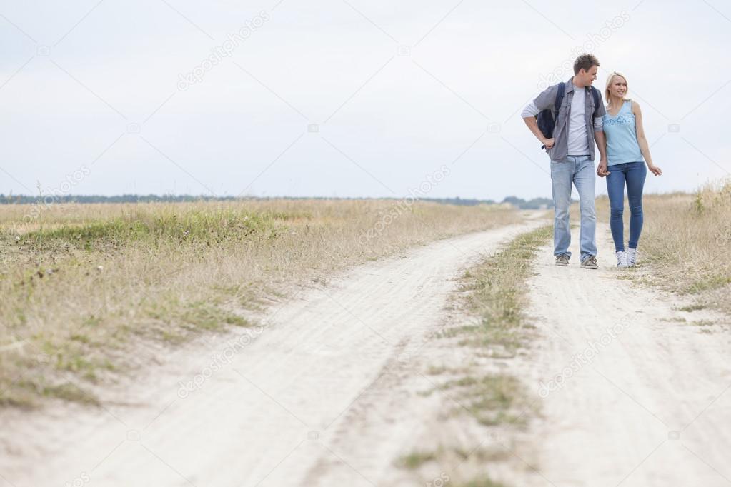 hiking couple standing on trail at field