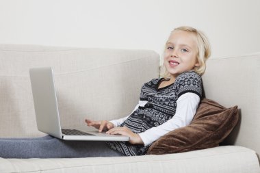 kanepede dizüstü kullanan kız