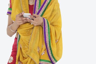 Woman in Indian clothing using cell phone clipart