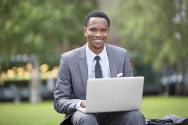 Afrikalı Amerikalı iş adamı dizüstü bilgisayar kullanıyor.