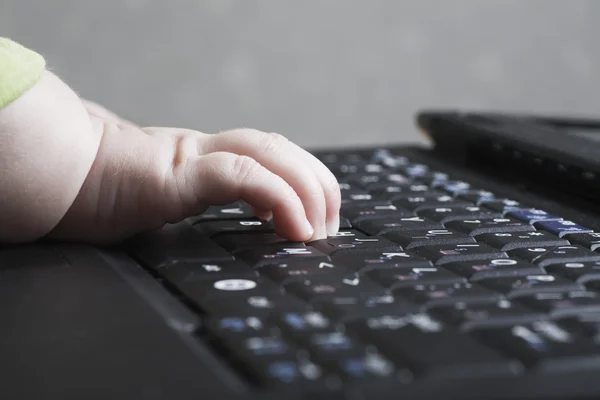Baby hand on keyboard — Stock Photo, Image