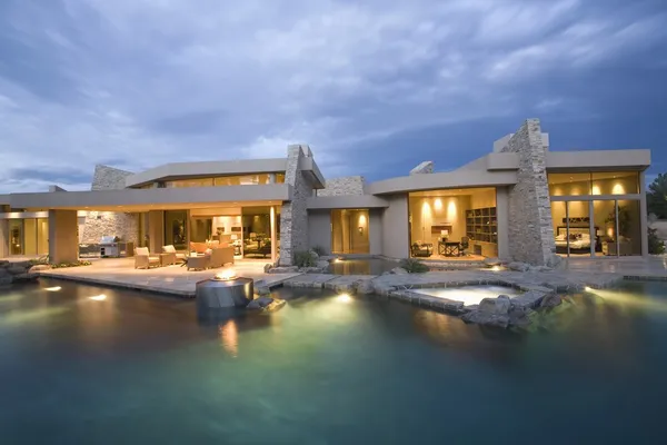 Swimming pool and house exterior at dusk — Stock Photo, Image