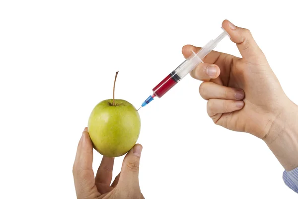 Man's hand injecting granny smith apple — Stock Photo, Image