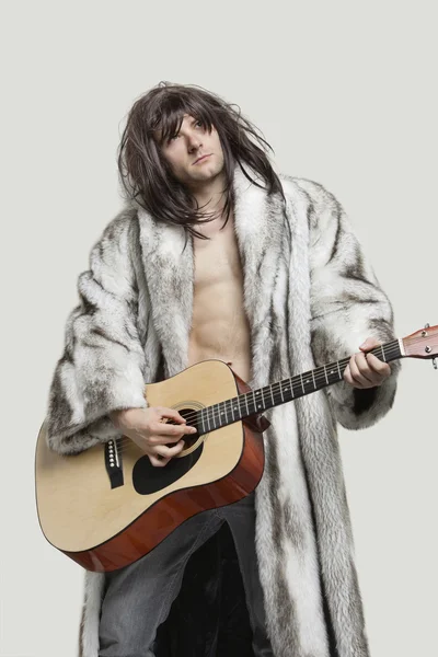 Man in fur coat playing guitar — Stock Photo, Image