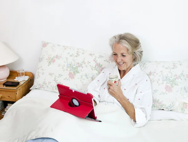 Femme âgée utilisant une tablette numérique — Photo