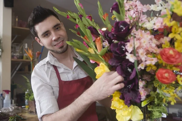 Florista trabalha em arranjo de flores — Fotografia de Stock