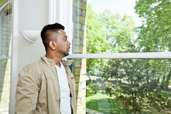 Indyjski człowiek patrząc w okno — Zdjęcie stockowe