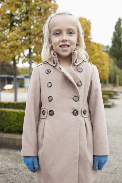 在冬天的外套站在公园中的女孩 — 图库照片