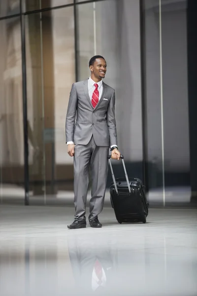 Hombre de negocios caminando con maleta de ruedas — Foto de Stock