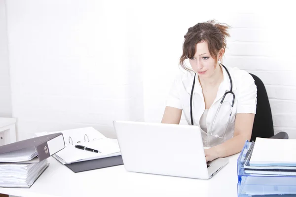 Doctor using laptop at desk — Stock Photo, Image