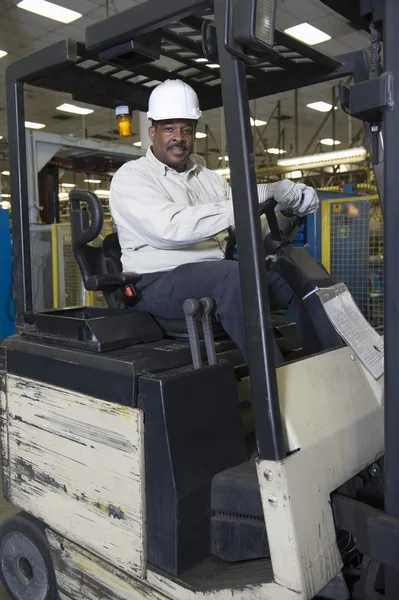 Man driving fork lift truck — Stock Photo, Image