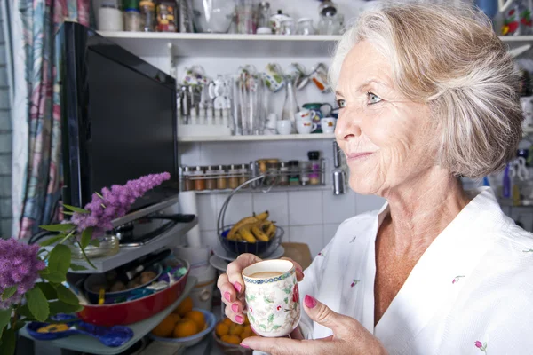 Seniores pensativo mulher segurando xícara de café — Fotografia de Stock