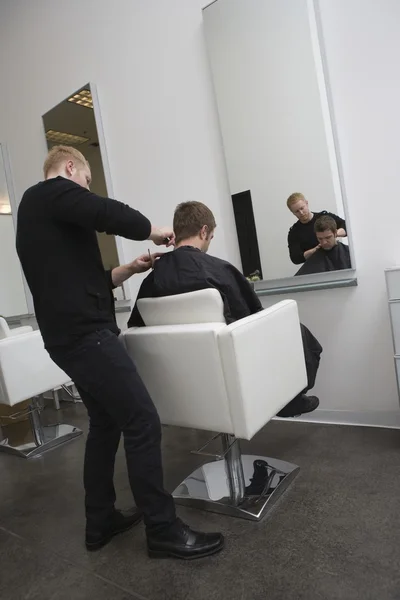 Unisex hairdresser  male client has his hair cut — Stock Photo, Image