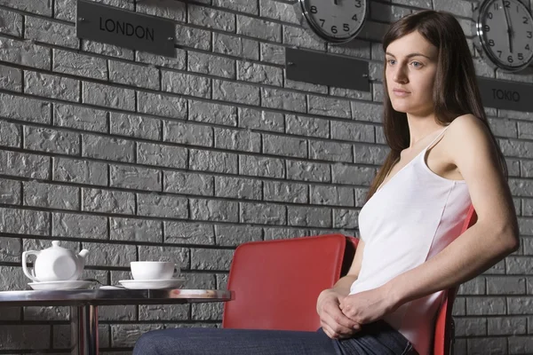 Jeune femme se relaxant dans un café — Photo