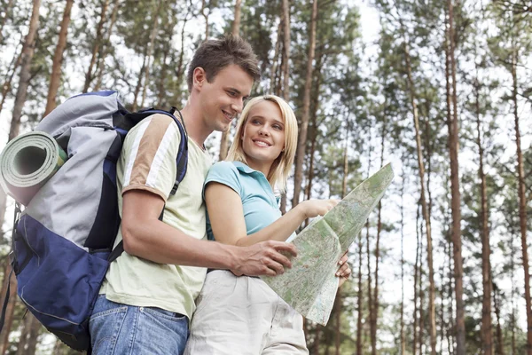 Backpackers reading map in forest — Stock Photo, Image