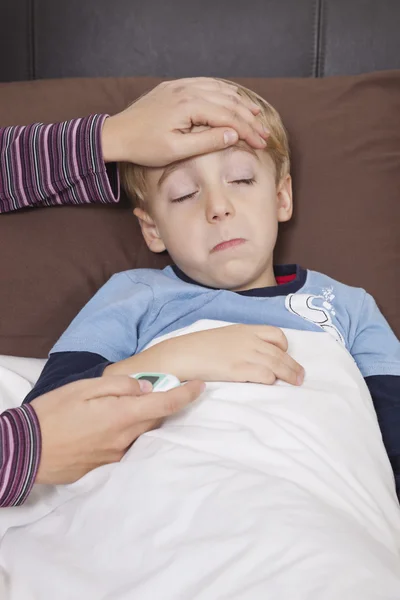 Mère avec thermomètre vérifiant la température — Photo