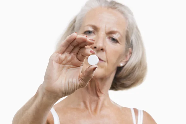 Senior woman holding pill — Stock Photo, Image