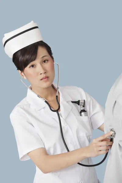 Doctor examining patient with stethoscope — Stock Photo, Image