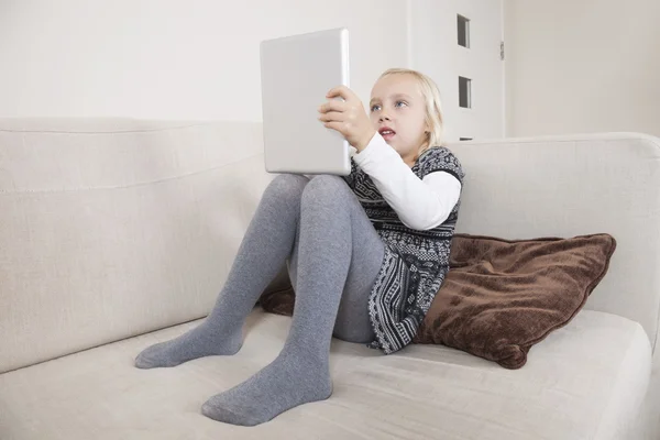 Gebruiken, tablet pc op sofa meisje — Stockfoto